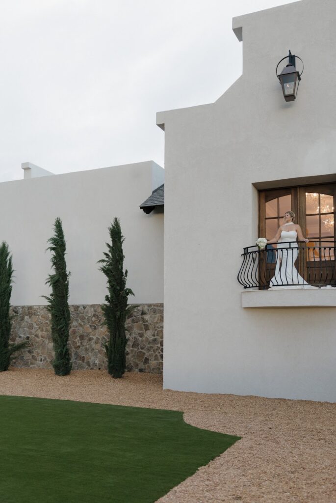 bride standing on the balcony overlooking the greenery at stone haven wedding venue
