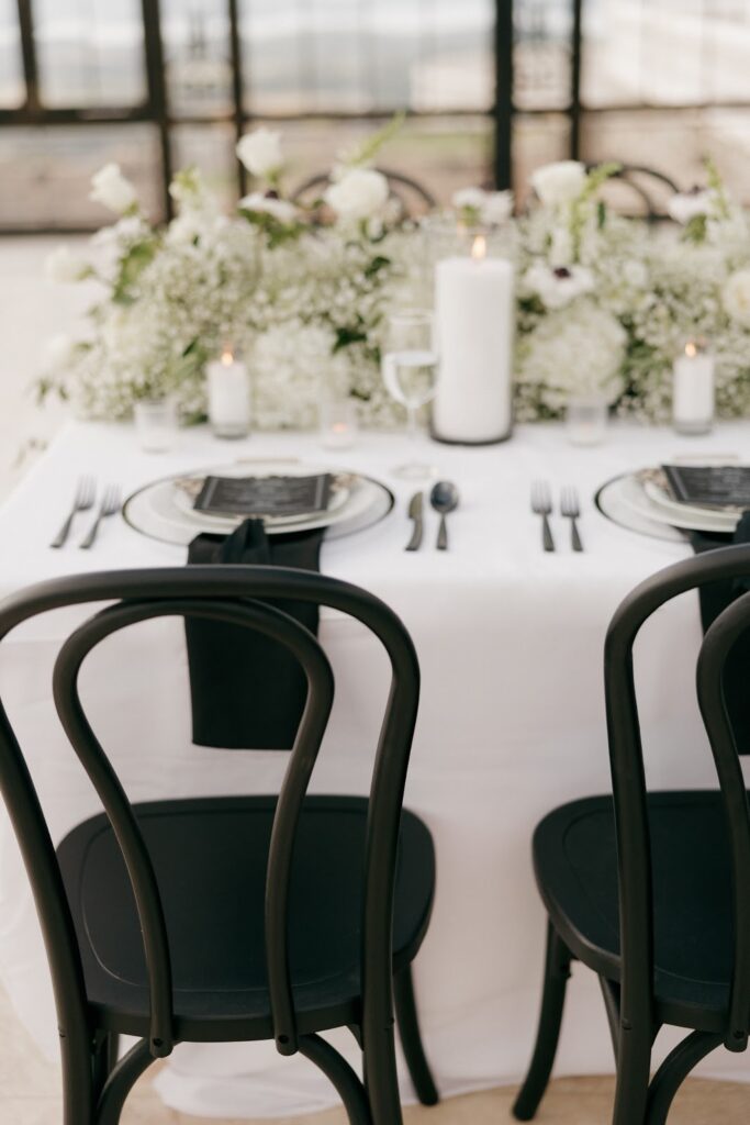 luxury wedding tablescape with black chairs, white tablecloth, and neutral decor at stone haven weddings