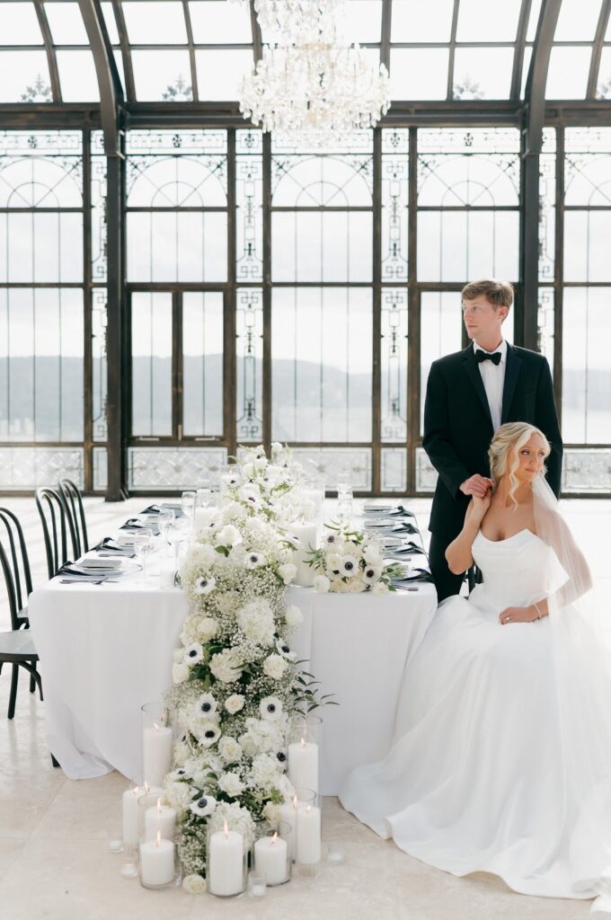 Bride and Groom sitting at a table in the atrium of stone haven weddings
